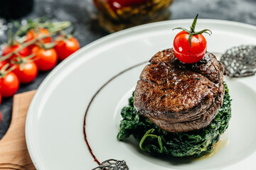 Tender lean medium rare beef fillet steak medallions with one sliced through to show the red meat with spinach, Restaurant menu, dieting, cookbook recipe