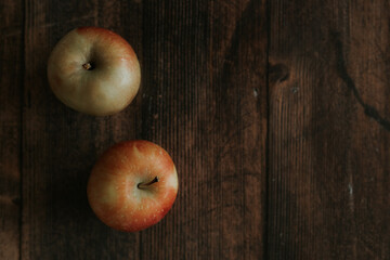 Apples from your own garden lie on a wooden table. Delicious juicy, beautiful apples lie on a dark wooden background. Selectiv focus. View from above