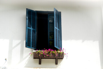 Blue window on a white wall in one of the many colonial houses in the Unesco town of Luang Prabang in Laos