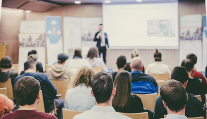 Business speaker giving a talk at business conference event.