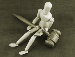 Mannequin and broken wooden judge gavel.