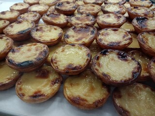 Close up of pastel de nata pastries the tray freshly delicious tasty baked hot custard pastries laid out for sale on gourmet pastry stall in TIME OUT food market in Lisbon Portugal Europe