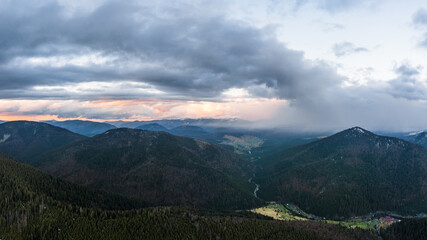Fototapeta premium Cloudy skies over the mountains, rainy spring clouds over the forest and mountain tops.