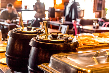 soup heated pots with ladle in cafe