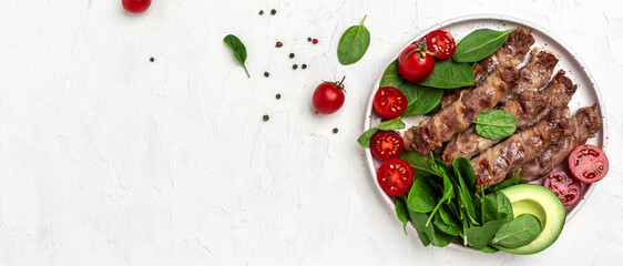 Baked minced meat wrapped in bacon with spinach, avocado and cherry tomato, Healthy fats, clean eating for weight loss. Keto paleo diet menu. top view