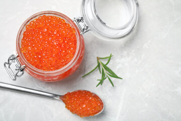 Delicious red caviar and rosemary on light grey table, flat lay. Space for text