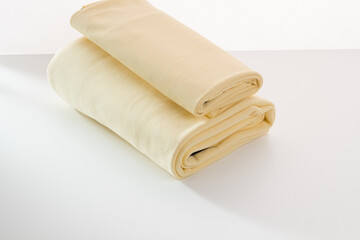 Rolls of bright colored fabric on a white background.