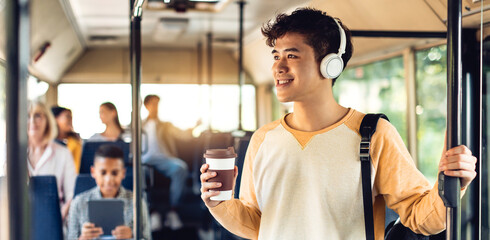 Beautiful smiling asian man listening music in bus - obrazy, fototapety, plakaty