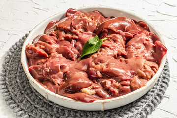 Raw chicken liver in a bowl. Fresh food ingredient and spices, trendy hard light, dark shadow