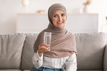 Muslim Woman Posing Holding Glass Of Water Drinking At Home