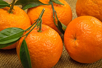 fresh ripe tangerines with leaves on wooden table