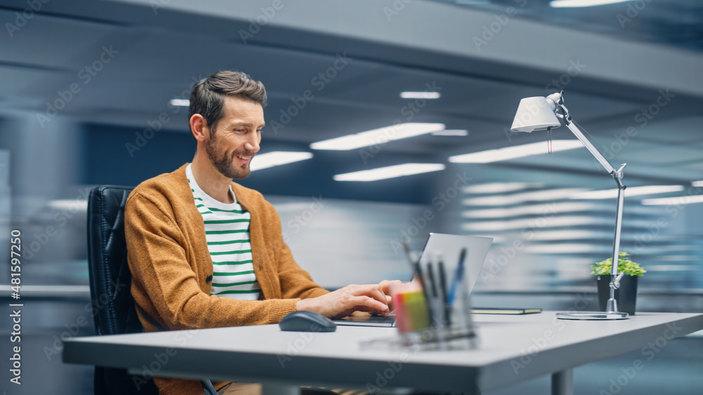 Poster Modern Office: Handsome Businessman Sitting at His Desk Working on a Laptop Computer. Man working with Big Data e-Commerce Analysis. Motion Blur Background Showing Active Work Day.