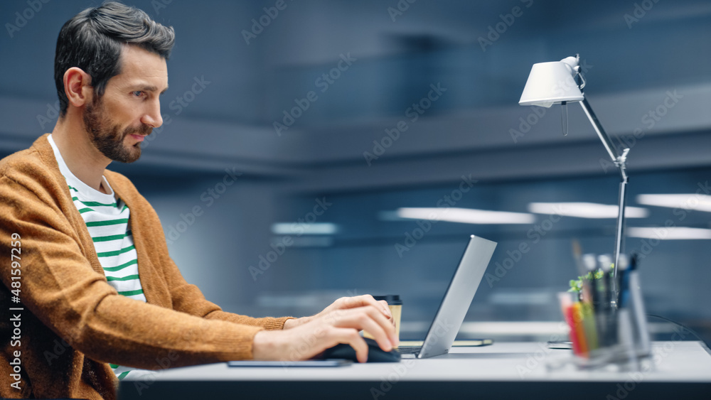 Aufkleber Modern Office: Handsome Businessman Sitting at His Desk Working on a Laptop Computer. Man working with Big Data e-Commerce Analysis. Motion Blur Background Showing Active Work Day.