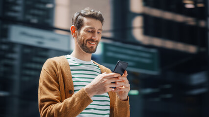 Street Shot: Portrait of Caucasian Man Using Smartphone in the Big City. Creative Professional...