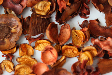 dried rose petals on a white background.dried petals in color are scattered on the table.a vase and dried rose petals in color on a white background.liaists in color close-up