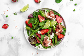 Healthy salad. green asparagus, strawberry, rocket and cottage cheese. Healthy balanced eating. banner, menu, recipe place for text, top view