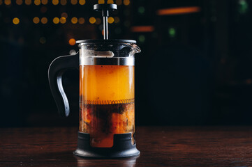 Yellow Tea in french press on a wooden table