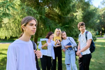 Obraz premium Male student 16, 17 years old with backpack, in school park