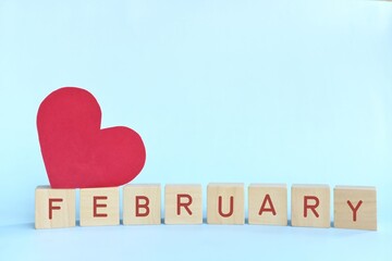 Love month of february in wooden blocks with red heart shape. Hello Valentine season celebration.