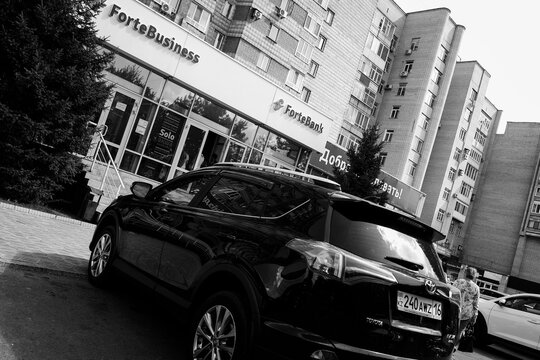 kazakhstan, Ust-Kamenogors, july 31, 2021: Soviet built apartment building. Forte Bank. Parking. Toyota Rav 4. Black and white photo