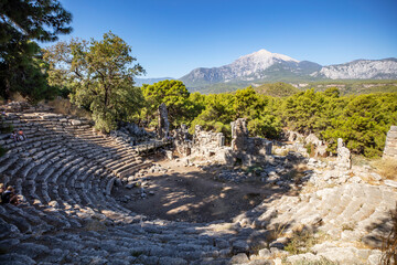 Naklejka premium Ruins of the aqueduct of the ancient ancient city of Phaselis illuminated by the bright sun in Pine forest, woods in sunny weather in Turkey, Antalya, Kemer. Turkey national nature landmarks.