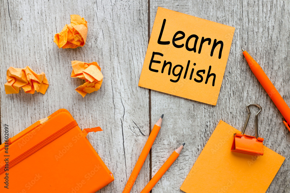 Poster learn english orange pen for notepad and colorful notes on background, orange torn note paper on woo