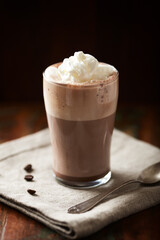 Coffee with whipped cream on dark background. Soft focus. Close up.	