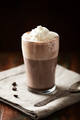 Coffee with whipped cream on dark background. Soft focus. Close up.