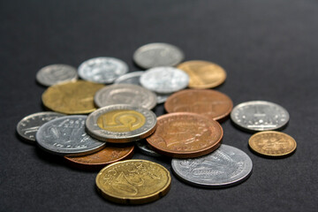 Coins of different countries. A scattering of coins on a black background. Shallow depth of field