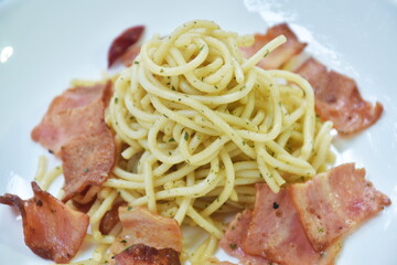 fried spaghetti topping crispy bacon and slice dry chili  on plate  