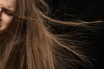 Close up of woman with static electric hair up on black background.