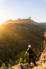 Man with gear doing rappelling sport in beautiful scenery of Roque Nublo mountain, Gran Canaria,...