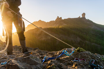 Man with gear doing rappelling sport in beautiful scenery of Roque Nublo mountain, Gran Canaria, Spain