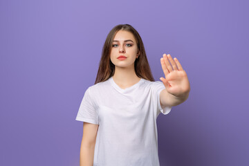 Displeased girl saying NO, showing rejection gesture, expressing her negative attitude, wears blank...