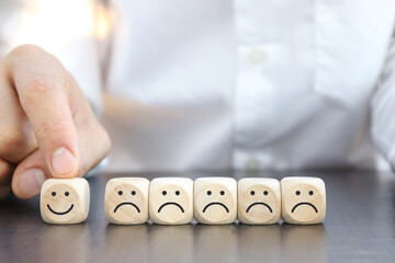 Hand holding wooden cube with smiley icon, Service Satisfaction Concept