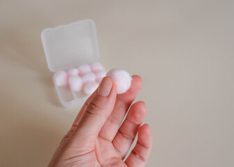 Shows a soft cotton ball in which a wax earplug is wrapped.