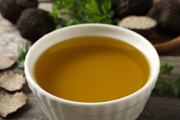 Fresh truffle oil in bowl on table, closeup