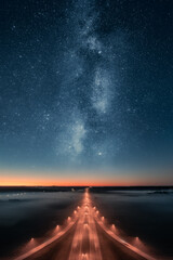 Epic view of highway at night with beautiful stars and milky way in the sky. Transportation...
