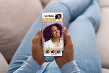 Afro-american woman choosing hair color before appointment with hairdresser