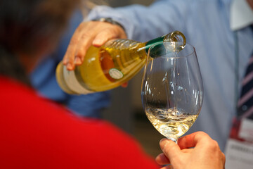 Pouring white wine into a wine during a party,close-up. High quality photo