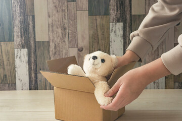 A child who handles an important doll. Bear doll in a cardboard box. Memories of goods....