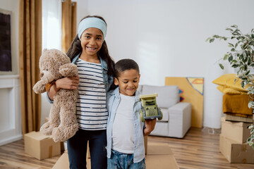 Loving siblings stand against backdrop of their parents' newly purchased apartment moving in out,...