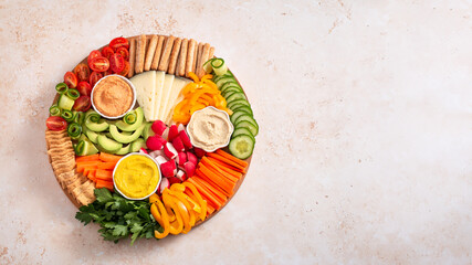 Colorful vegan Charcuterie board with raw vegetables and whole wheat snacks