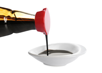 Pouring soy sauce into bowl against white background