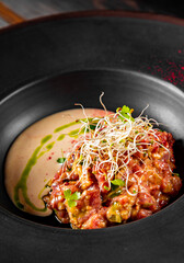 Raw beef meat tartare in black plate