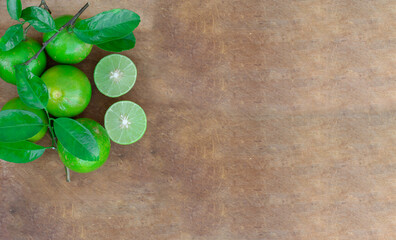 Fresh lime (lemon) and green leaf on wooden background.