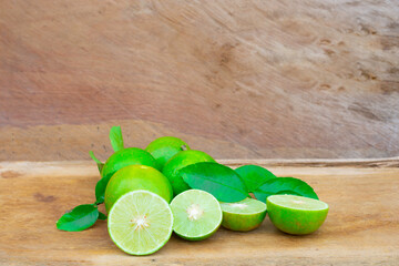Fresh lime (lemon) and green leaf on wooden background. copy space.
