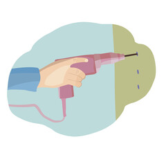 The hand drills a hole in the wall with a drill.
