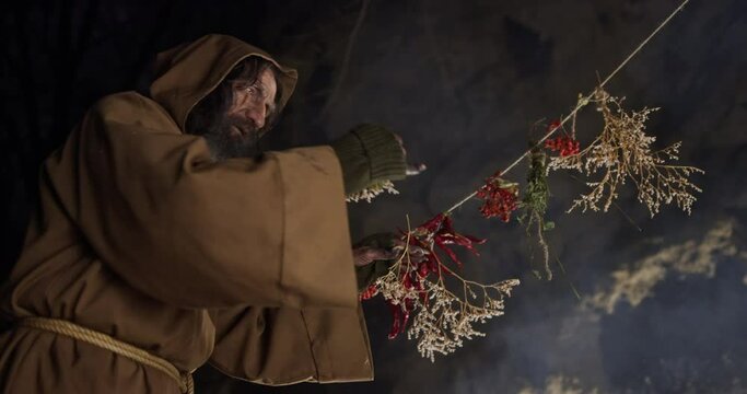 Senior wizard brewing potion in cave