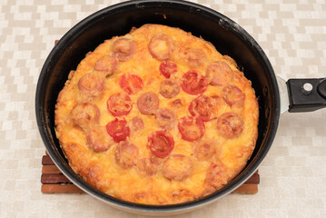 Ready to eat homemade pizza with sausages, tomatoes and cheese just from hot air oven. Top view with selective focus. Process of cooking pizza, step 12